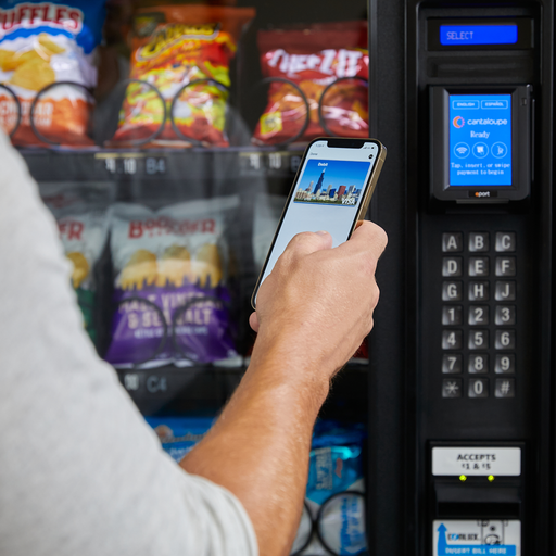 Man making mobile payment on Engage card reader on a vending machine